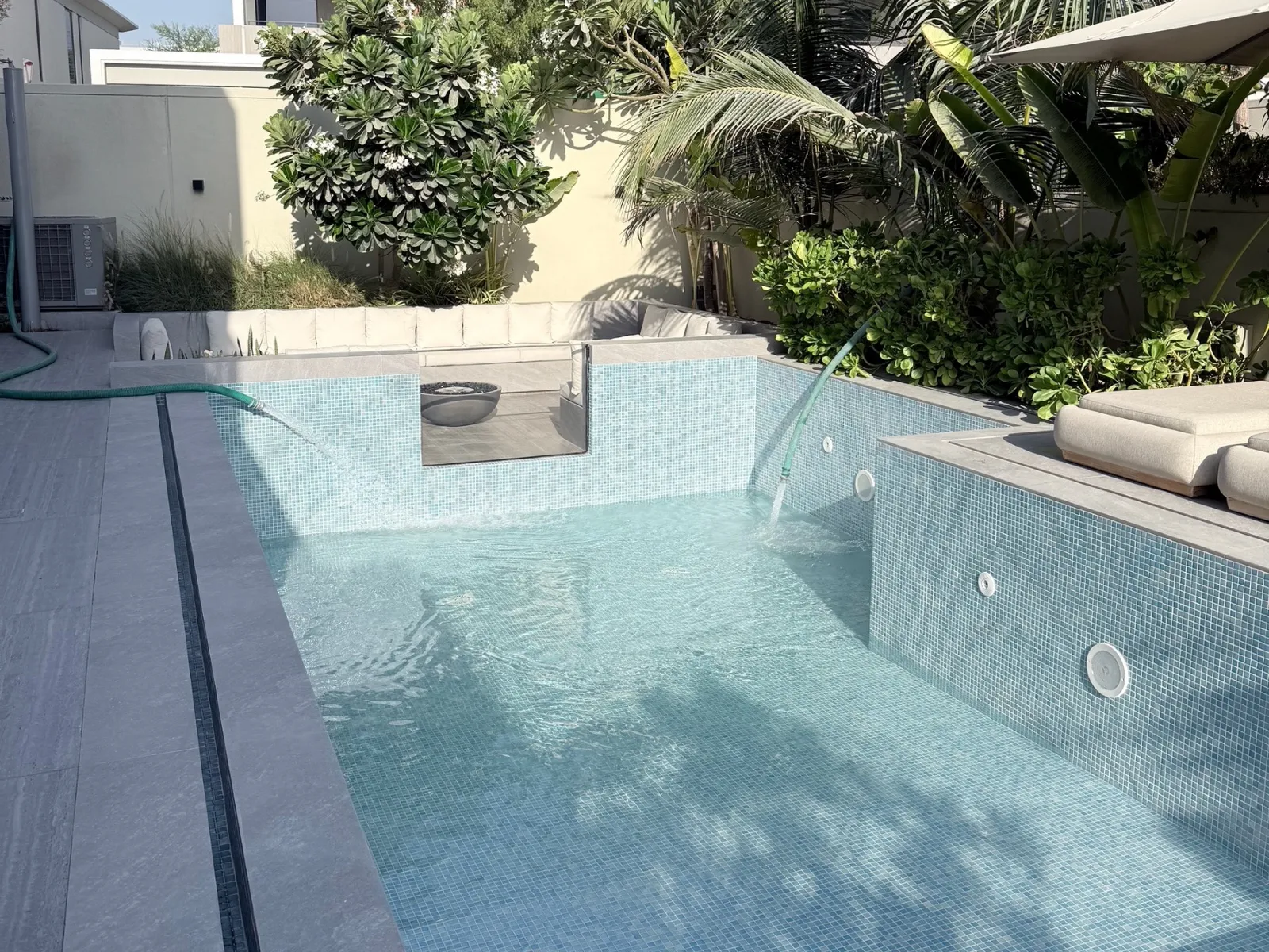 A villa swimming pool in Dubai being topped up with sweet water from a tanker hose